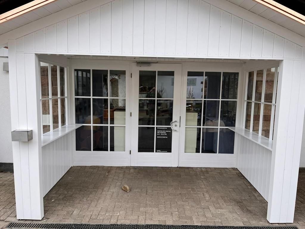 Ein weißes Haus mit überdachter Veranda 