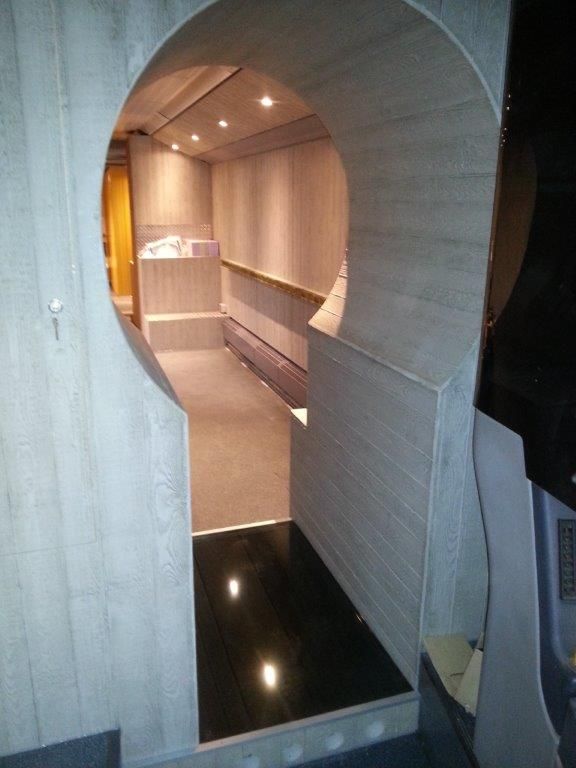 Eine Tür mit einem runden Loch in der Wand, die zu einem Raum führt.