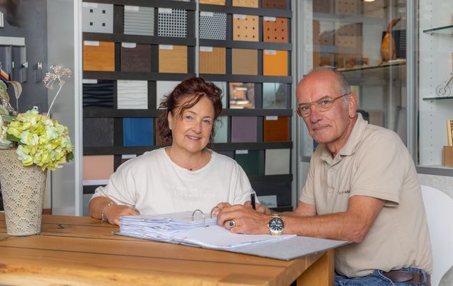 Herr und Frau Müllerschön sitzen an einem Tisch.