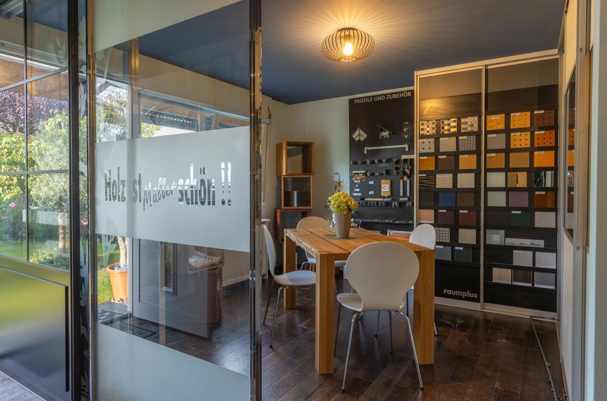 Ein Raum mit einem Tisch und Stühlen und einer Glastür.