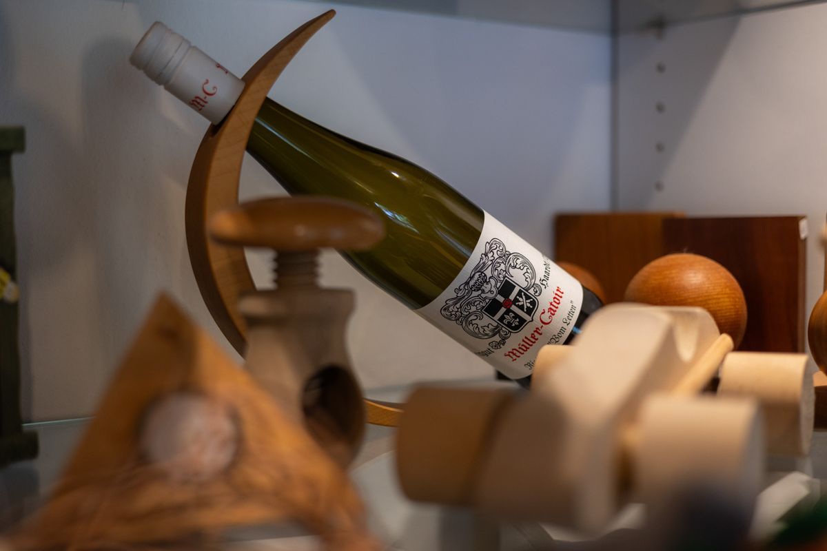 Eine Flasche Wein steht auf einem Holzregal