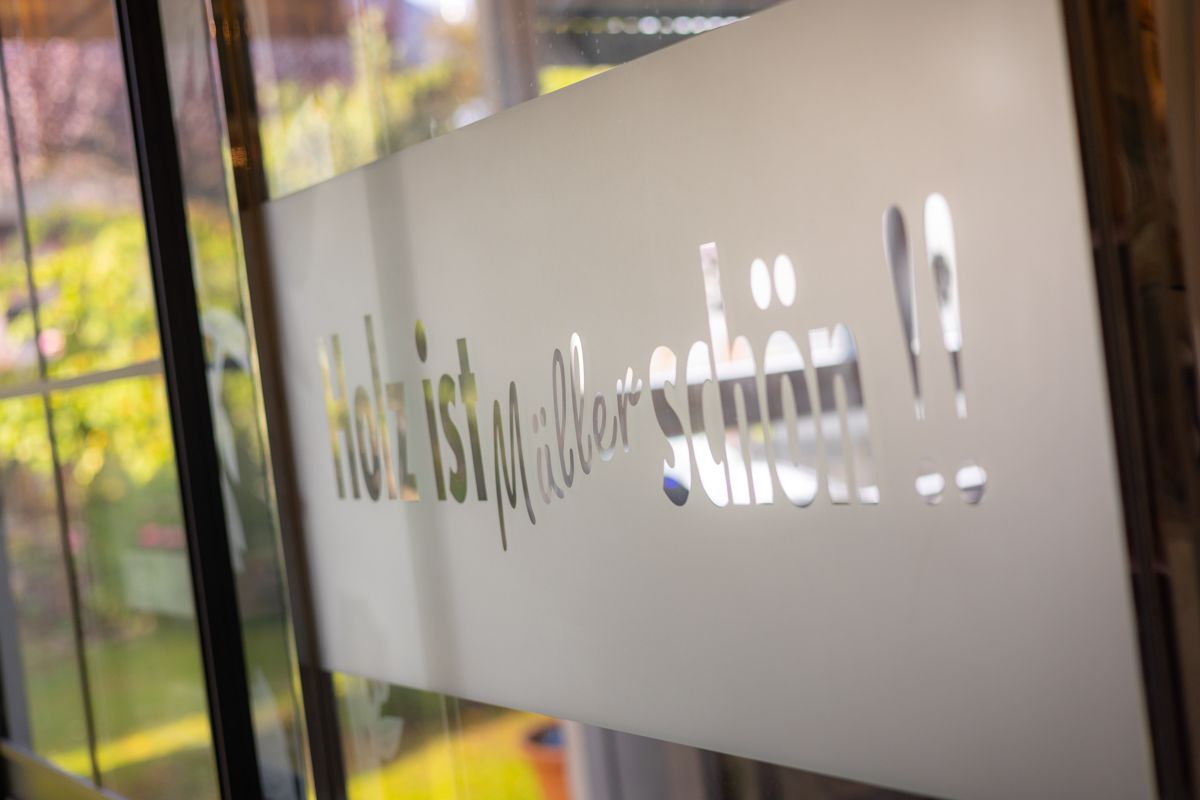 Eine Nahaufnahme einer Milchglastür mit einem Schild darauf.