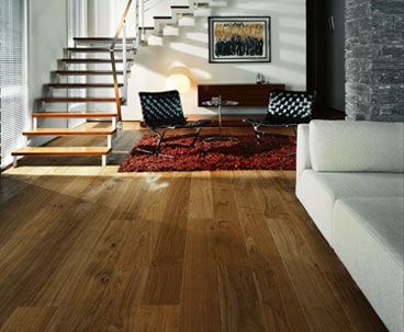 Ein Wohnzimmer mit Parkettboden und Treppe