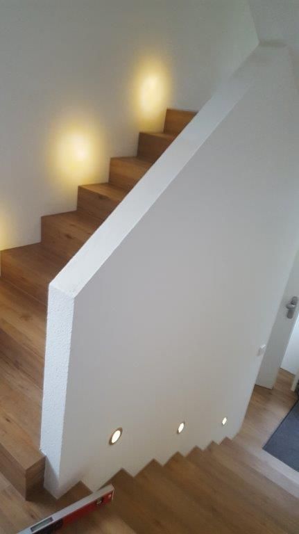 Eine Treppe mit Holzstufen und einem weißen Geländer