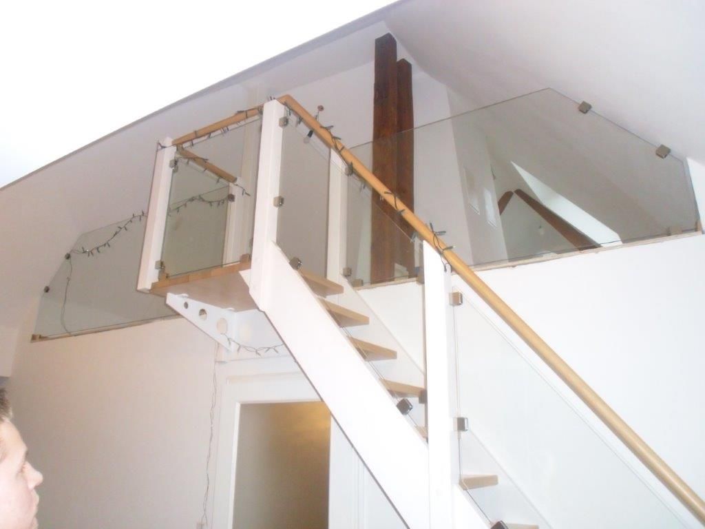 Eine weiße Treppe mit einem Holzgeländer und einem Glasgeländer