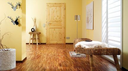 Ein Wohnzimmer mit Holzboden und gelben Wänden.