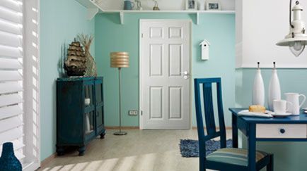 Ein Raum mit einem Tisch und Stühlen und einer Tür