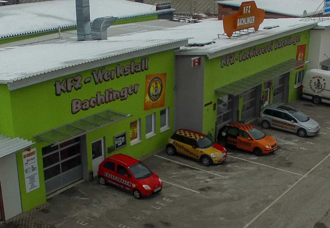 Ein grünes Gebäude mit davor geparkten Autos