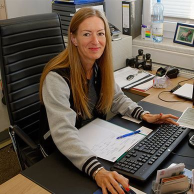 Eine Frau sitzt an einem Schreibtisch mit Tastatur und Maus