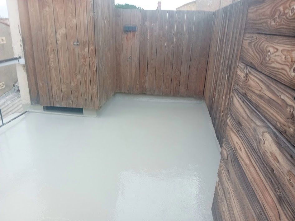 Un employé vu du dessus applique une résine sur un toit