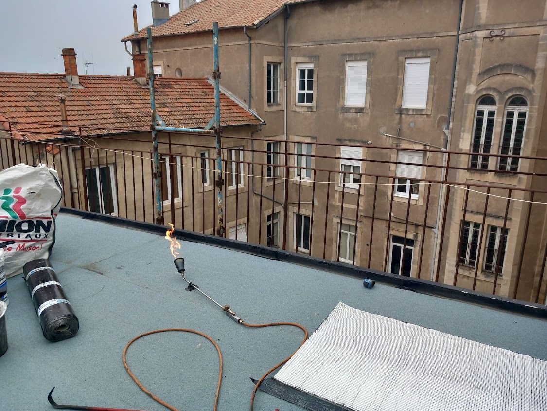 L'étanchéité au béton en rouleau en cours d'exécution. Le chalumeau est allumé