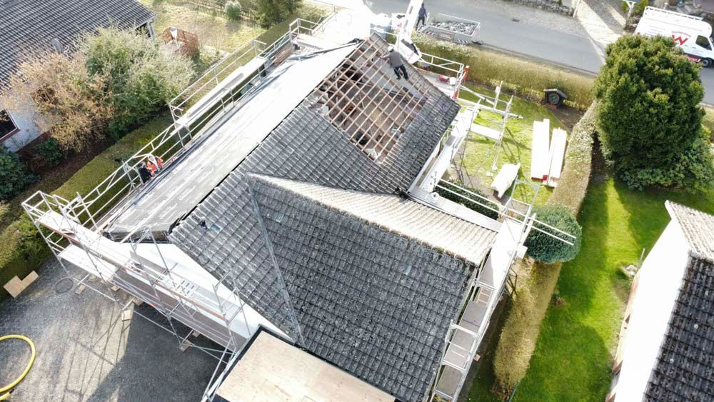 Eine Luftaufnahme eines im Bau befindlichen Hauses mit Gerüst auf dem Dach.