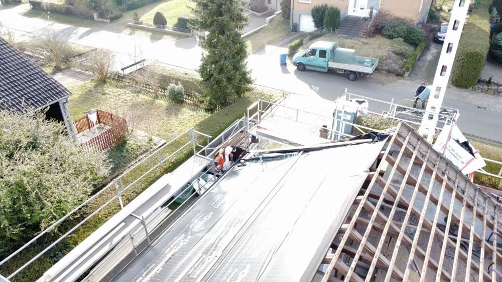 Eine Luftaufnahme eines Daches, das mit einem Kran gebaut wird.