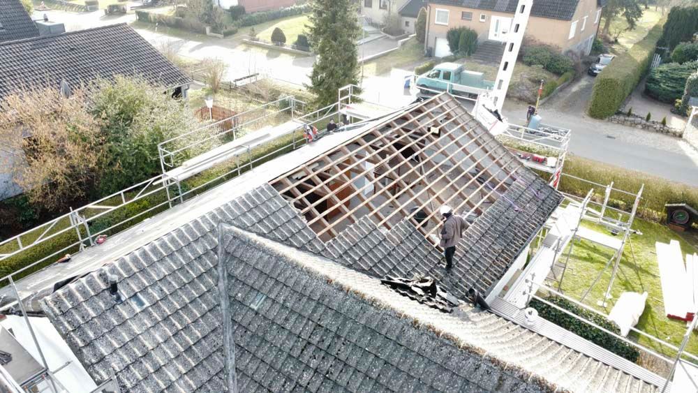 Eine Luftaufnahme eines im Bau befindlichen Dachs, auf dem ein Mann steht.