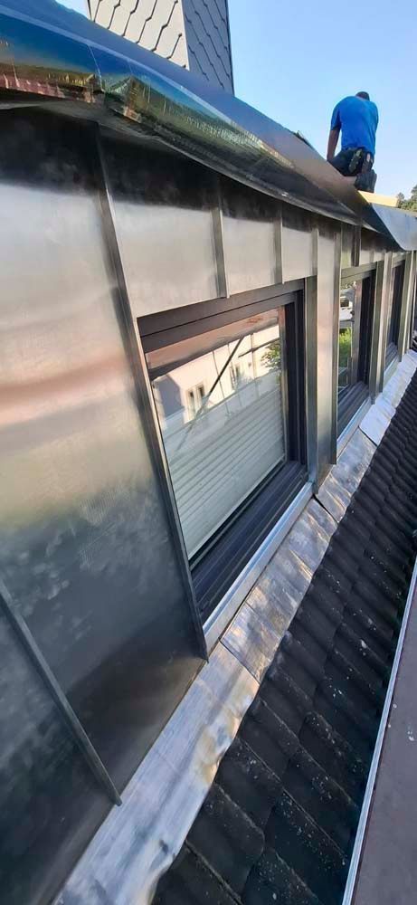 Ein Mann sitzt auf dem Dach eines Gebäudes.