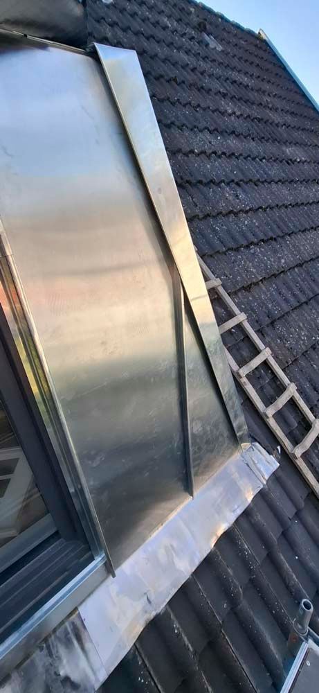 Ein Dach mit einem Fenster und einer Leiter darauf.