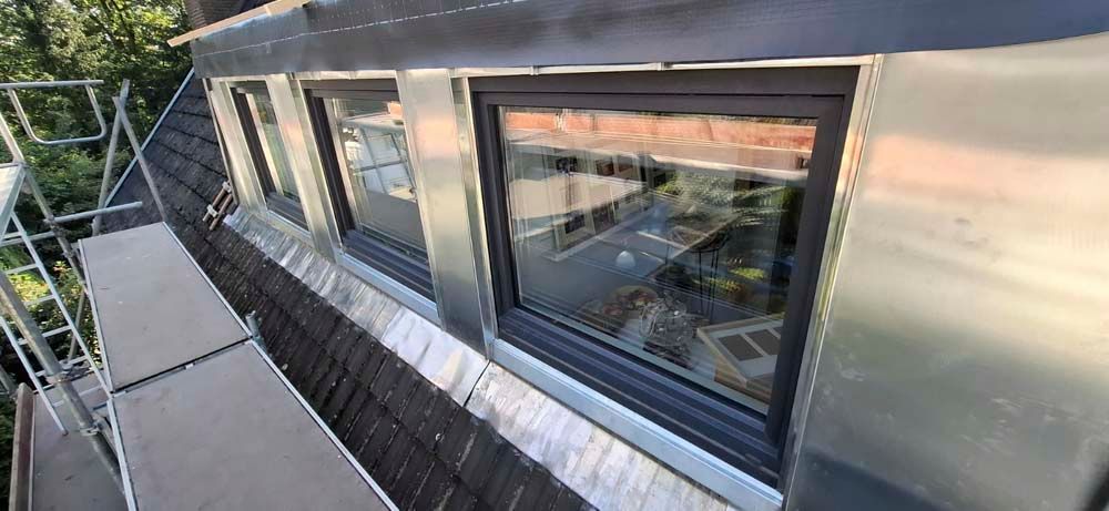 Ein Dach mit zwei Fenstern und einem Gerüst darauf.