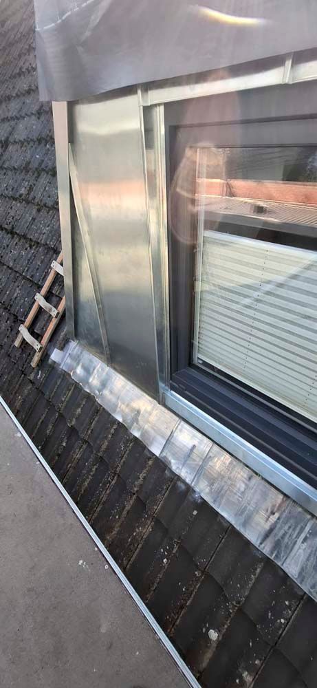 Ein Fenster an der Seite eines Gebäudes mit einer Leiter daneben.