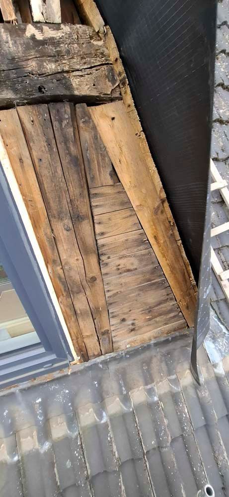 Ein Mann steht auf einem Holzdach.