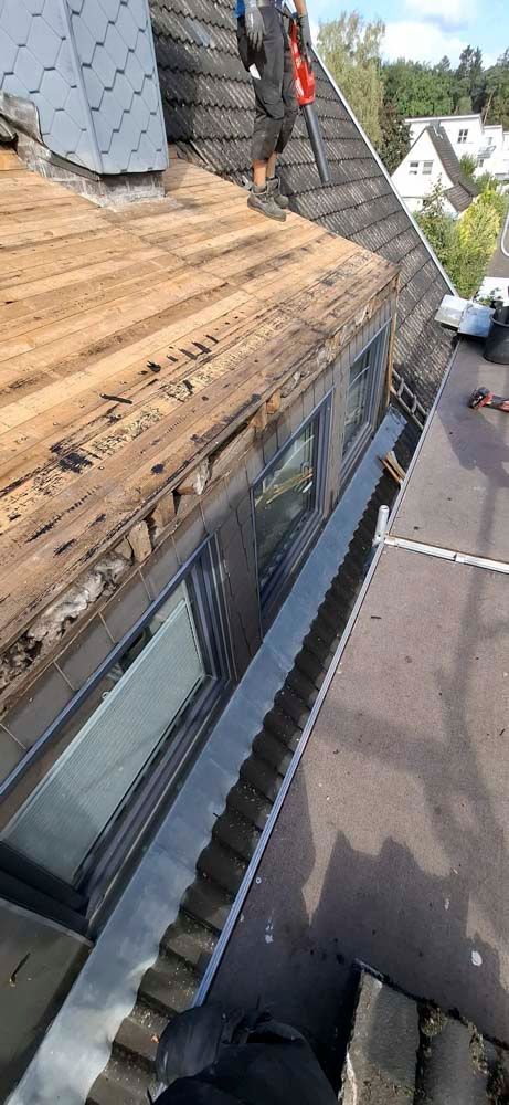 Ein Mann arbeitet auf dem Dach eines Gebäudes.