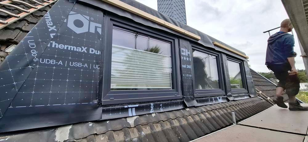 Ein Mann arbeitet auf dem Dach eines Gebäudes.