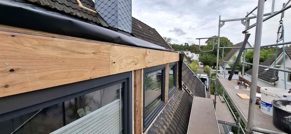 Ein im Bau befindliches Gebäude mit Holzdach und Gerüst.