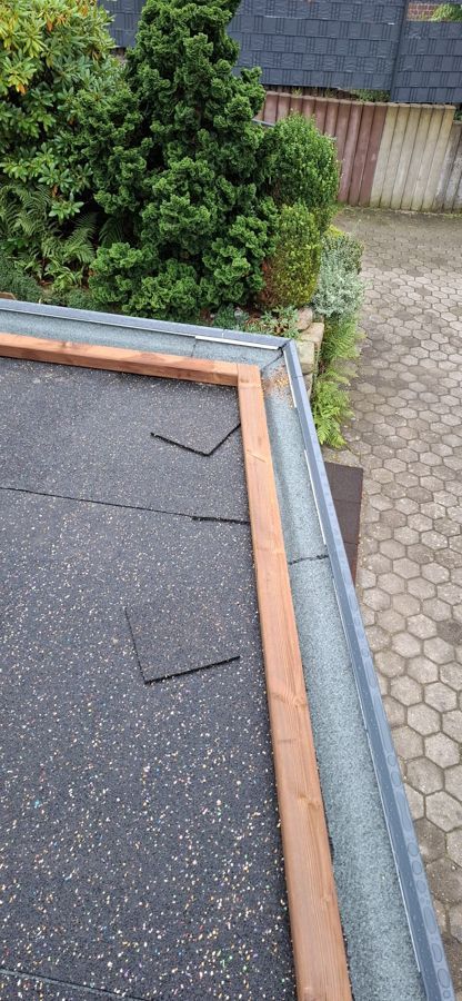 Eine Nahaufnahme eines Daches mit Holzverkleidung und Dachrinne.