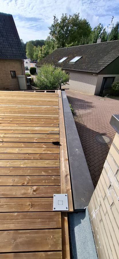 Auf dem Dach eines Hauses wird eine Holzterrasse gebaut.