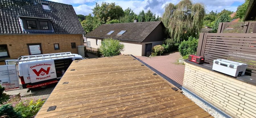 Ein schwarzes Dach mit ein paar Bäumen im Hintergrund