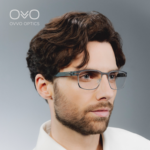 Mann mit grauumrandeter Brille, der mit neutralem Gesichtsausdruck leicht zur Seite blickt. Studioaufnahme.