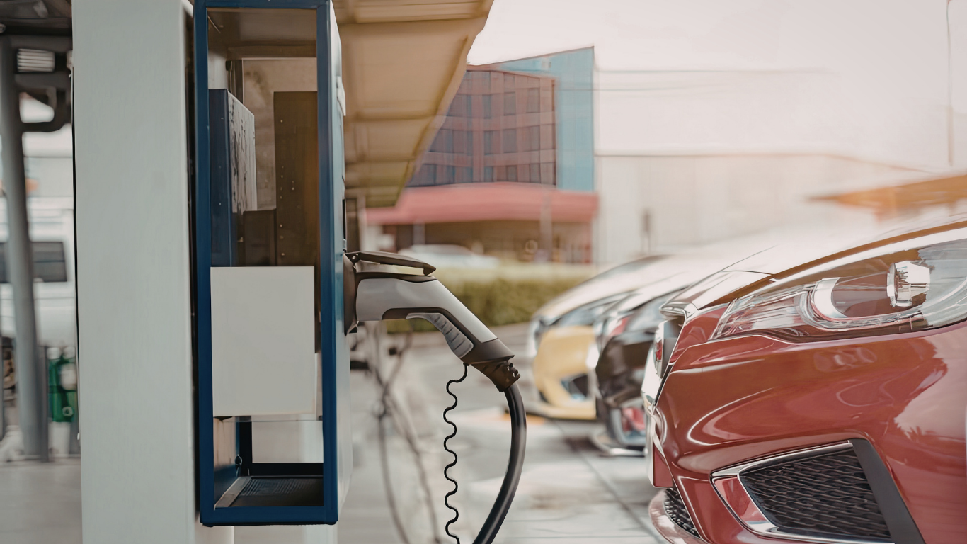 Electricista trabajando dentro de un panel eléctrico, usando guantes, con herramientas y componentes visibles.