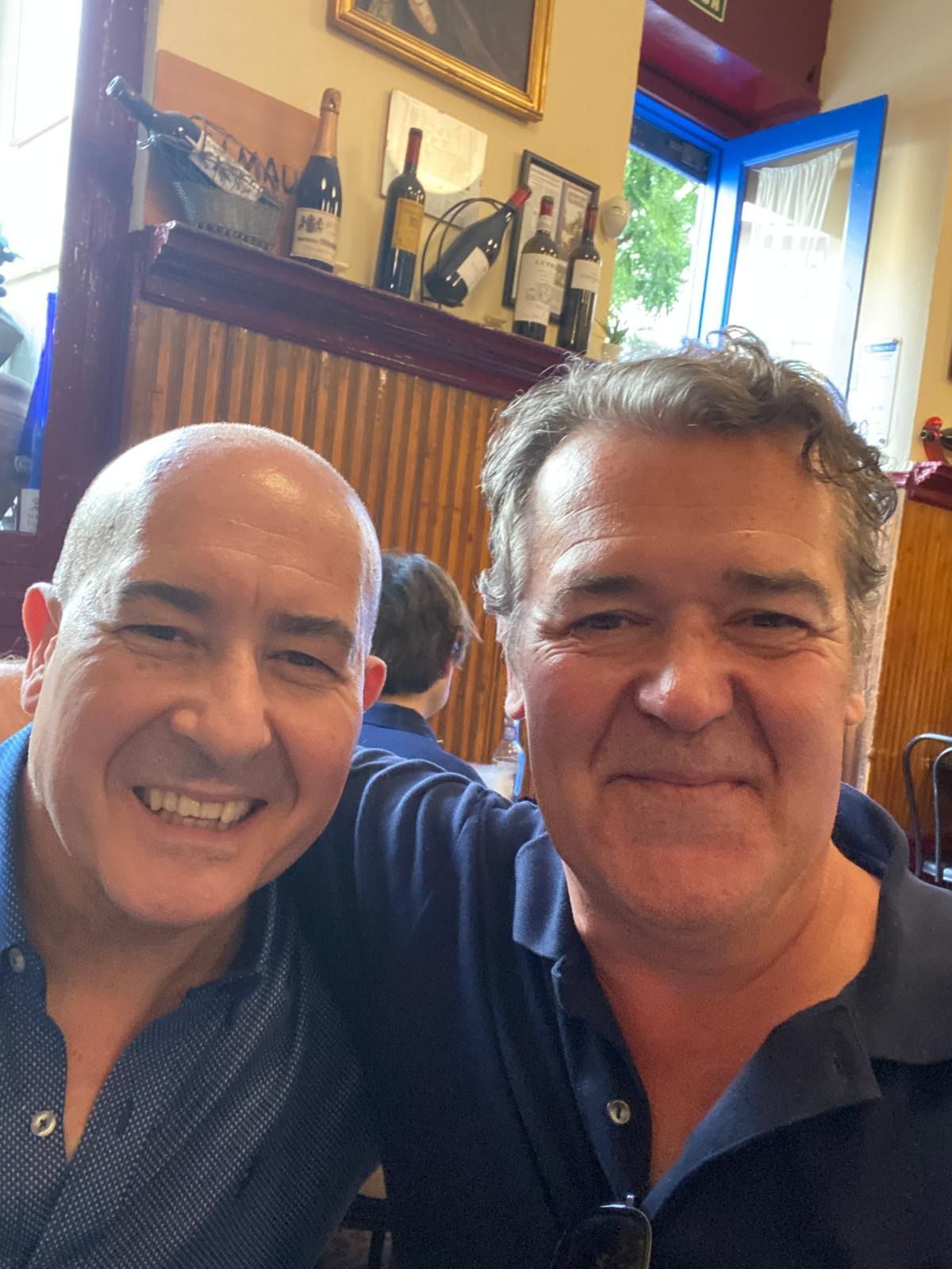 Dos hombres posan para una foto juntos en un restaurante.