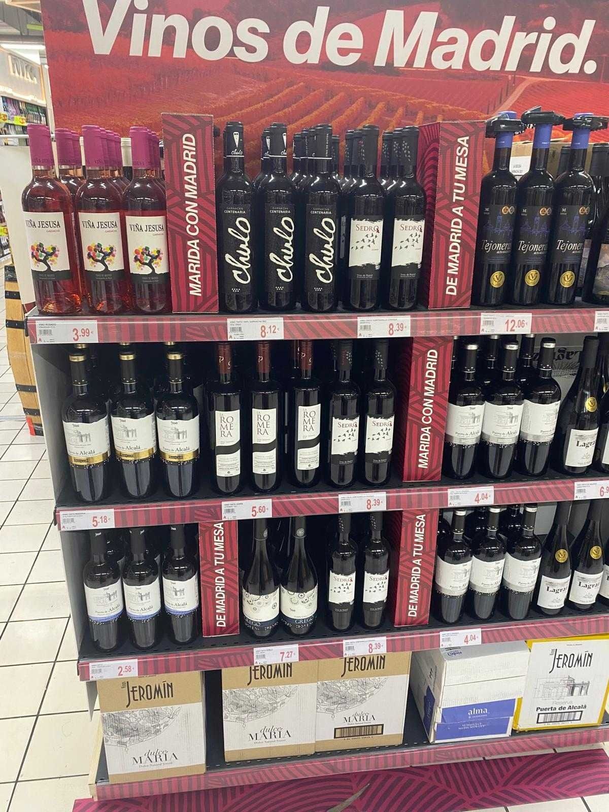 Una exhibición de vinos en una tienda con un cartel que dice vinos de madrid