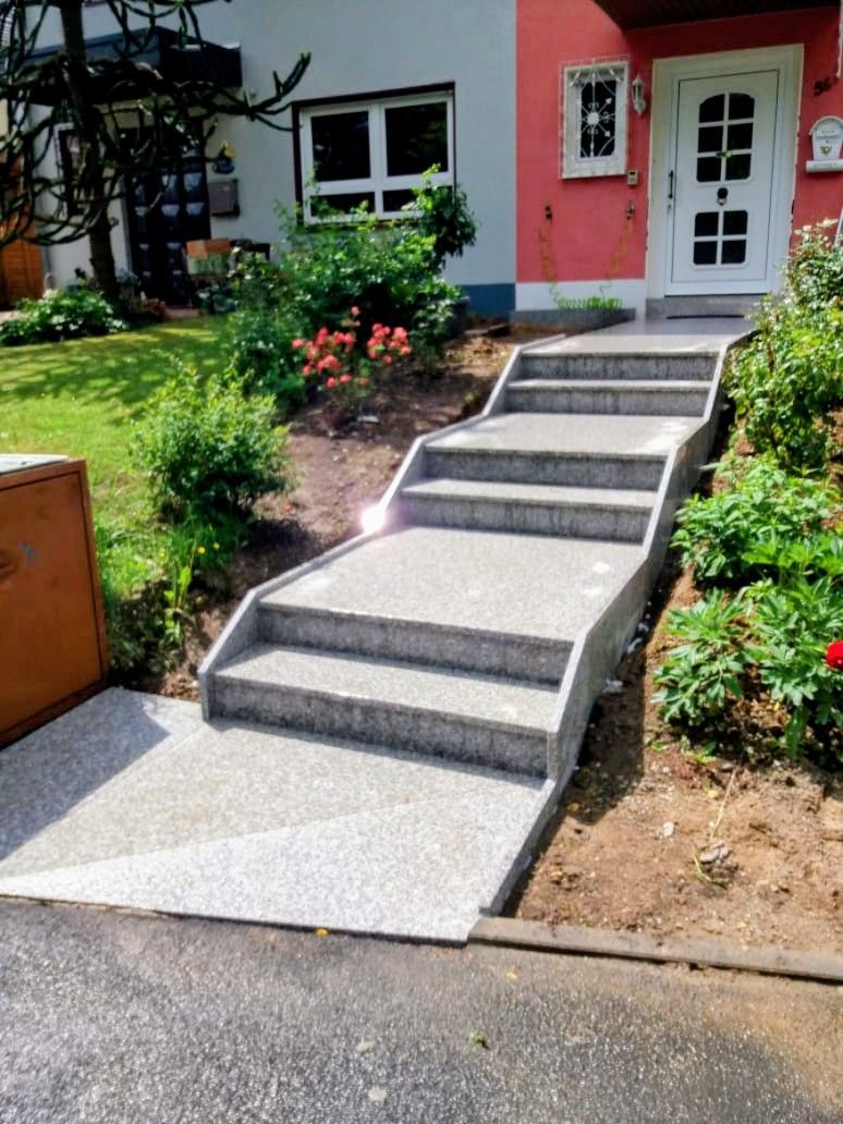 Treppe Bianco Sardo, geflammt – Natursteintreppe mit geflammter Oberfläche und Metallhandlauf am Hauseingang