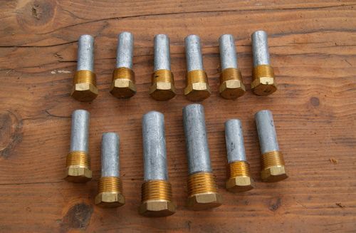 Diez casquillos metálicos pequeños colocados sobre una mesa de madera