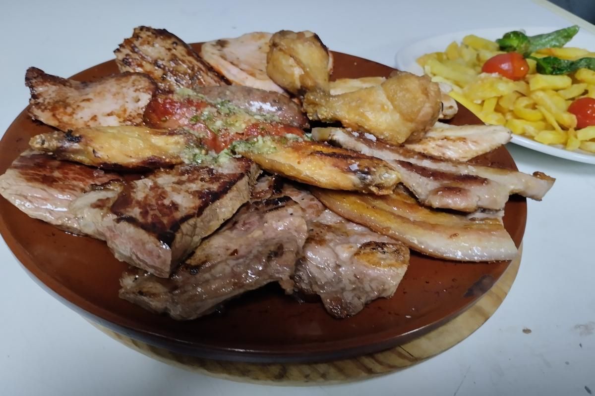Carnes a la parrilla en un plato marrón, ensalada de pasta de fondo.