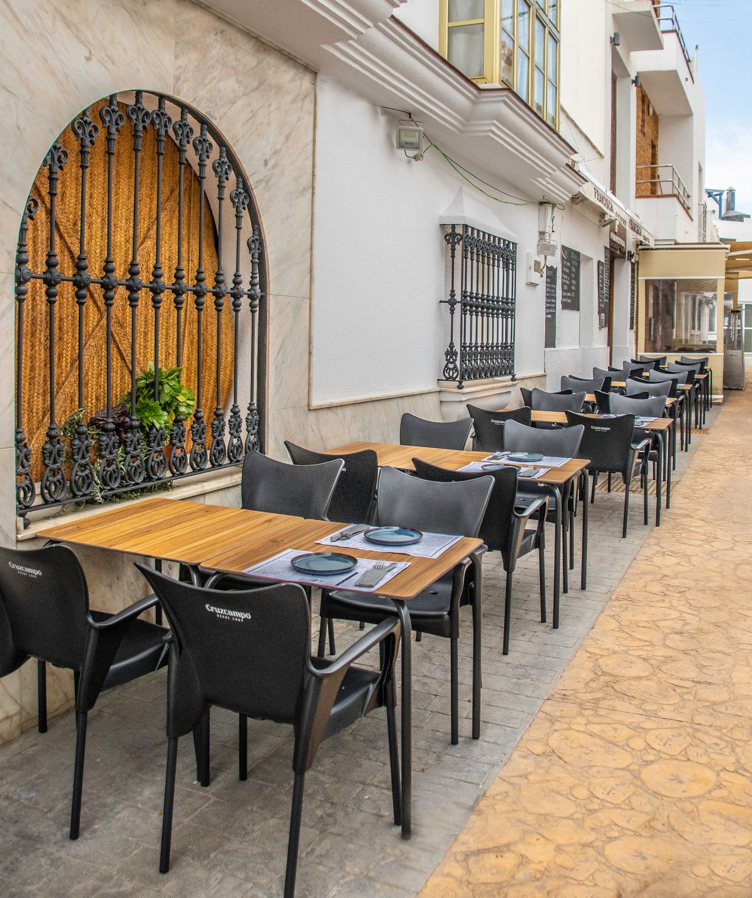 Una fila de mesas y sillas frente a un edificio