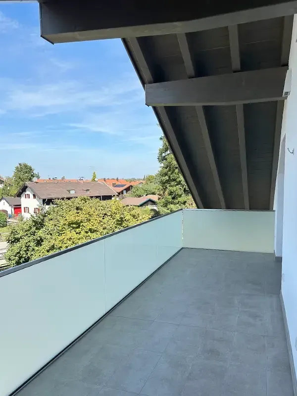 Ansicht der Dachkonstruktion eines modernen Einfamilienhauses mit sichtbaren Trägern und blauem Himmel.