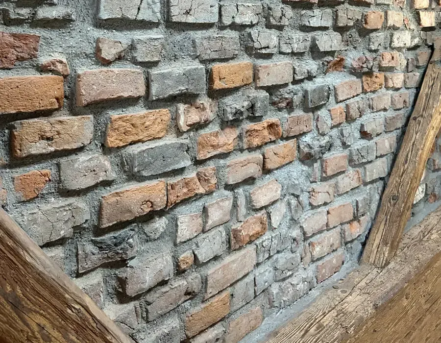 Freigelegte historische Naturstein- und Ziegelwand während der Sanierungsarbeiten.