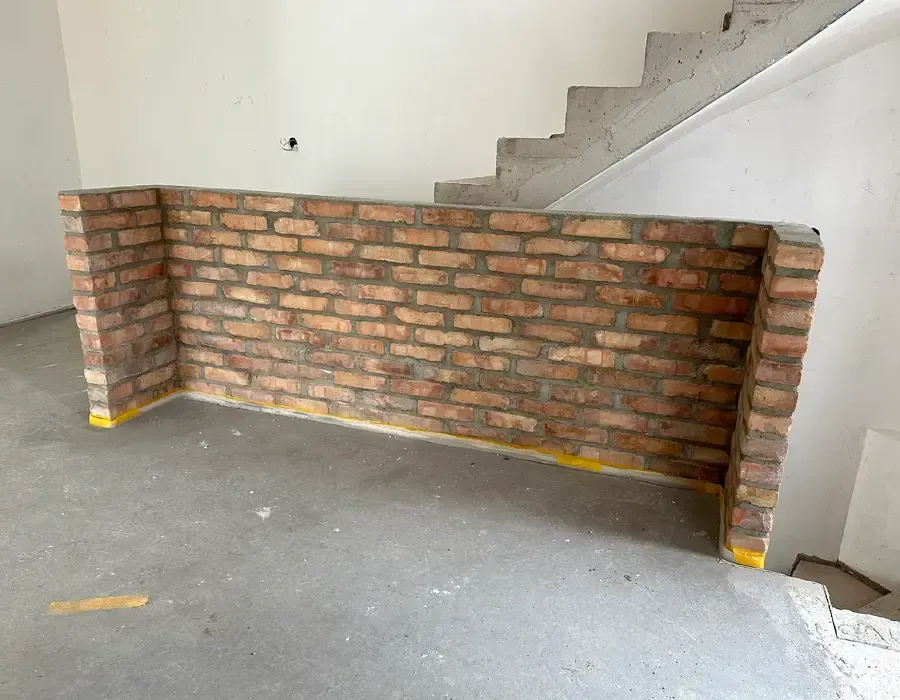 Neu errichtete Sichtziegelwand als Treppenabgrenzung im Innenbereich eines Umbaus.