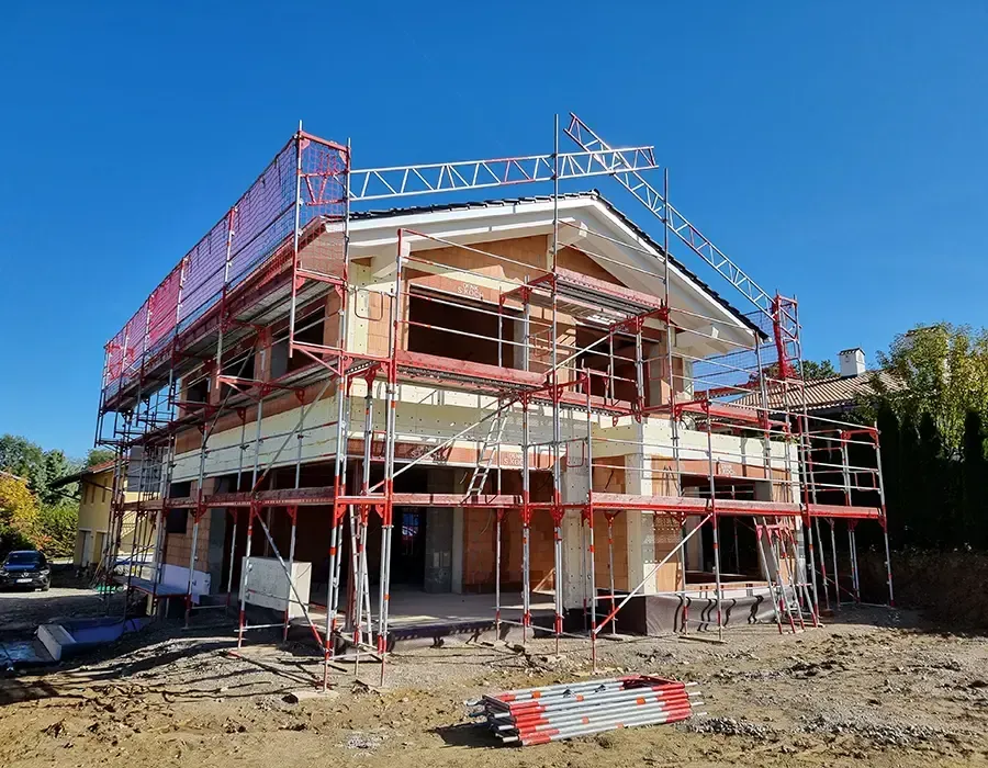 Einfamilienhaus im Neubau mit Gerüst während der Rohbau- und Fassadenarbeiten.