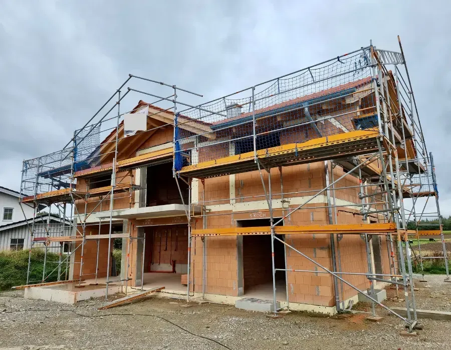 Neubau eines Wohnhauses mit Holz-Dachstuhl und umlaufendem Baugerüst.