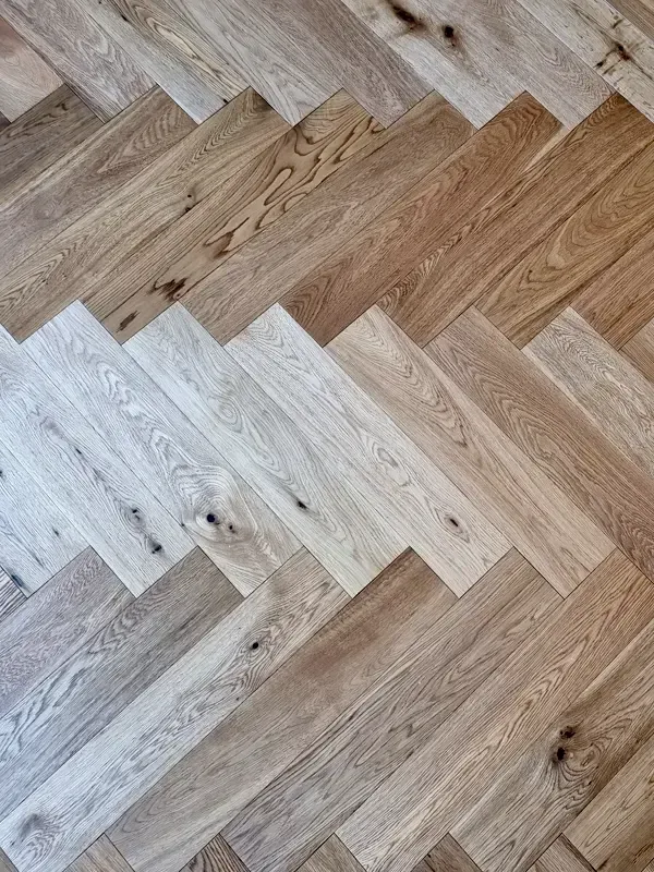Hochwertiger Fischgrät-Parkettboden aus Holz im schlüsselfertig ausgebauten Wohnbereich.
