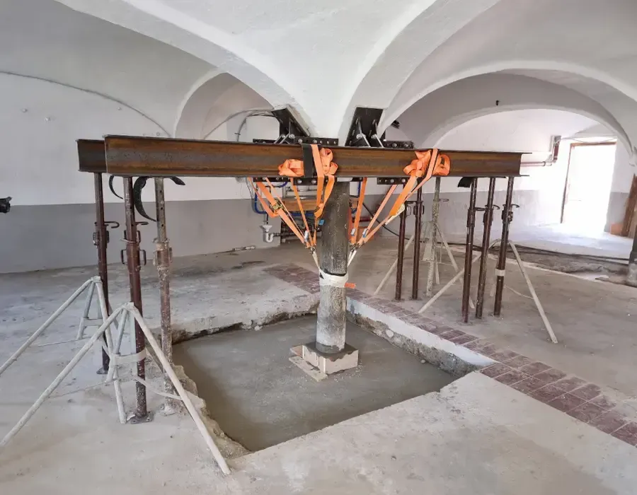 Historischer Innenraum mit Gewölbedecke während der Sanierung, abgestützt durch Stahlträger und Baustützen.