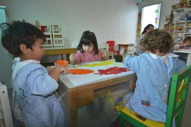Un gruppo di bambini è seduto a un tavolo e gioca con i giocattoli