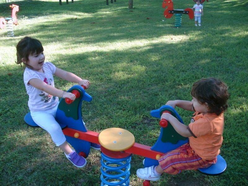 Due bambine stanno giocando su un'altalena in un parco