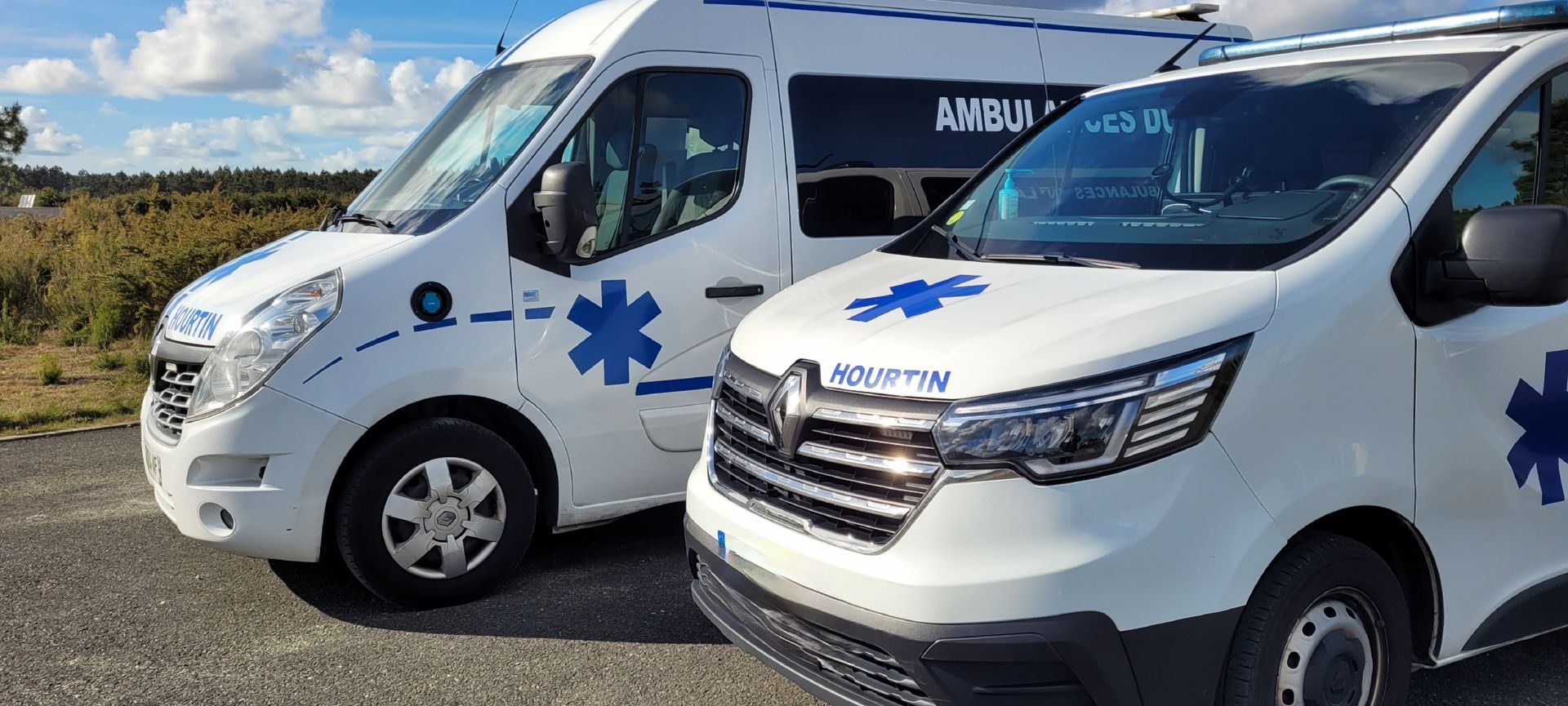 Deux ambulances stationnées sur une surface de gravier.