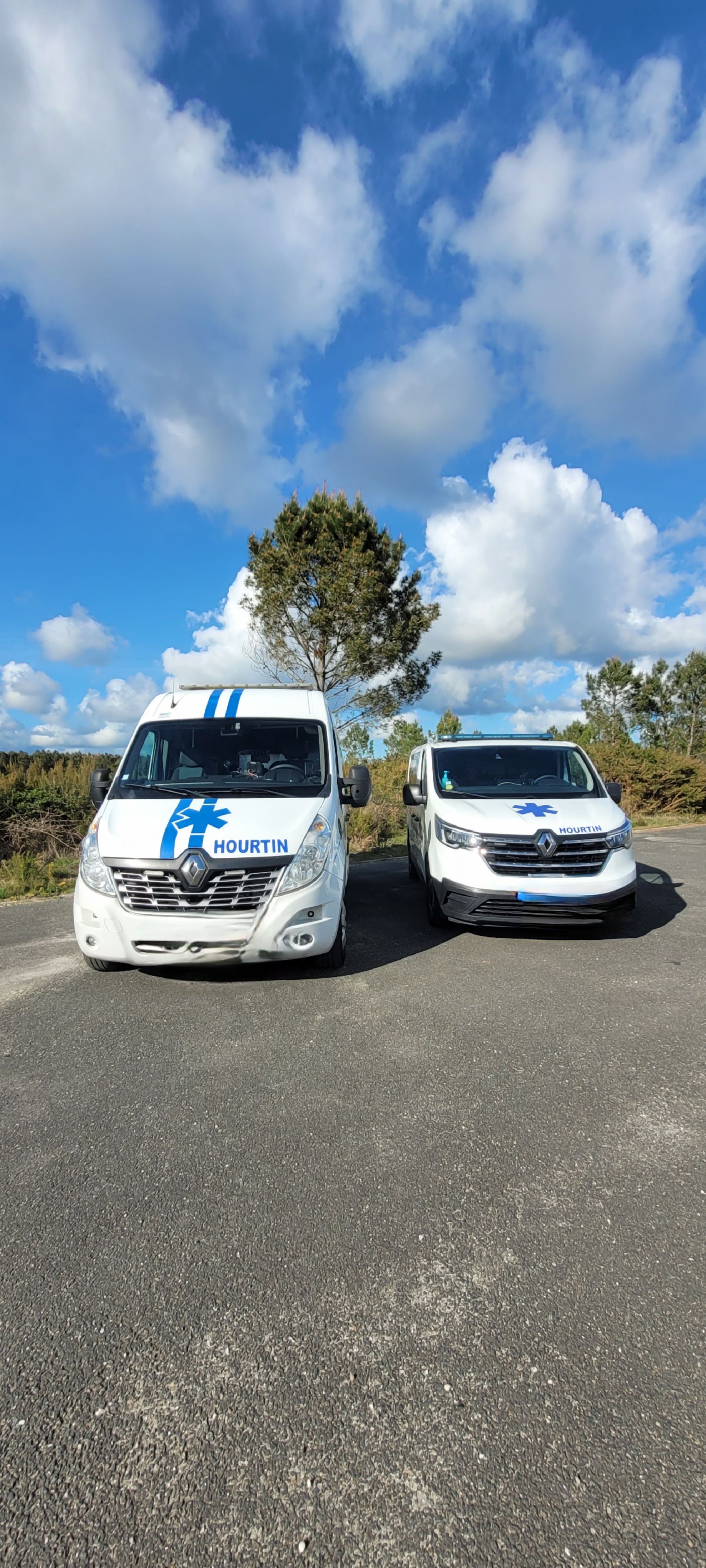 Deux camionnettes garées côte à côte sur une route asphaltée.