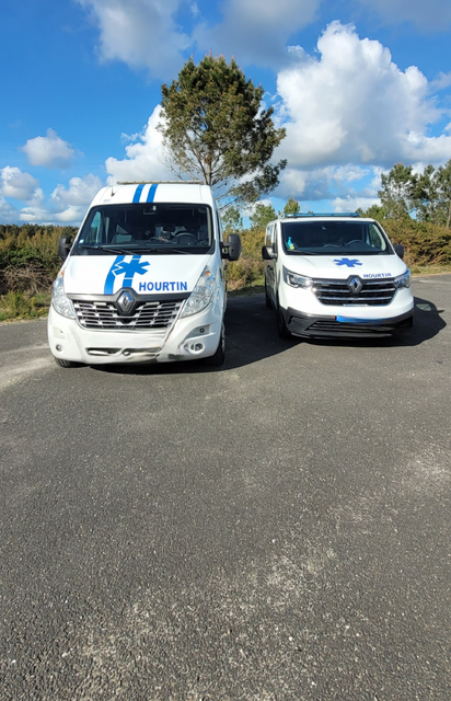 Deux ambulances garées côte à côte sur une route asphaltée.