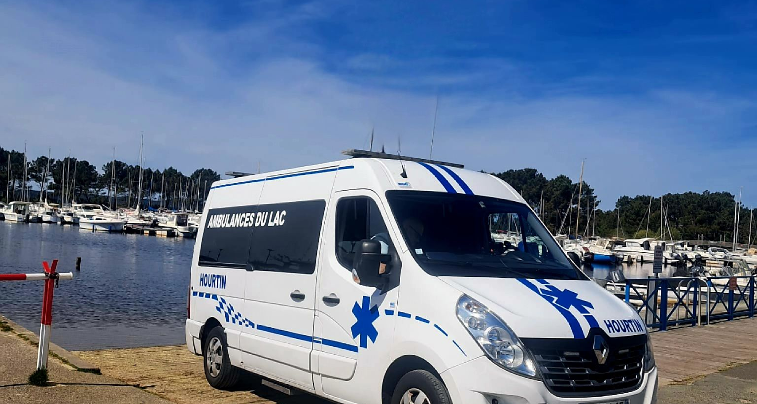 Une ambulance Renault garée dans un port de plaisance.